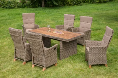A patio dining set with chairs and a table is arranged on a grassy lawn.