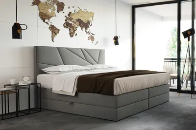A bedroom with a bed, world map on the wall, and a floor lamp.