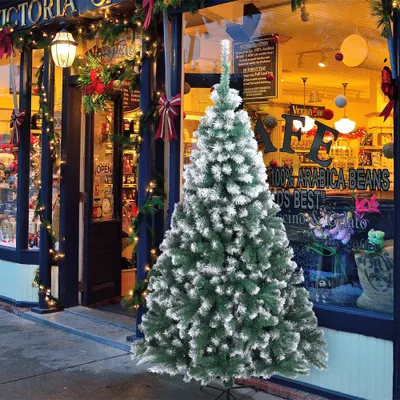 A decorated Christmas tree stands in front of a shop entrance during the holiday season.