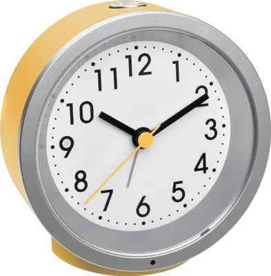 A close-up studio shot of a yellow analog alarm clock.