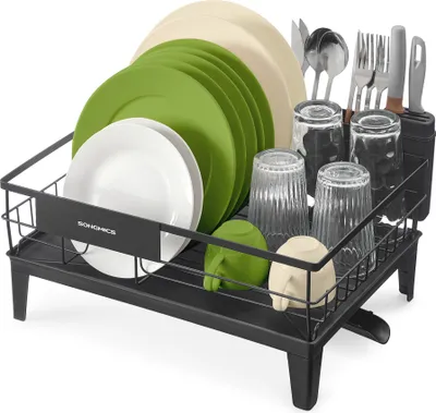 A black dish drying rack filled with plates, bowls, cups, and cutlery.