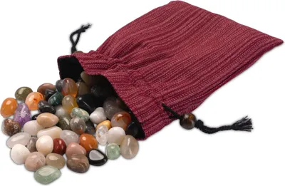 A pile of colorful, polished stones spilling out of a dark red drawstring bag.