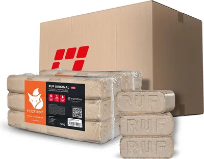 A cardboard box with a red logo is in the background, and several packages of wood briquettes are in the foreground.