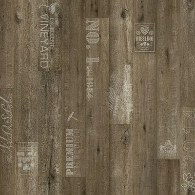A close-up view of vinyl flooring with a wood grain texture and vintage-style text and graphics printed on it.