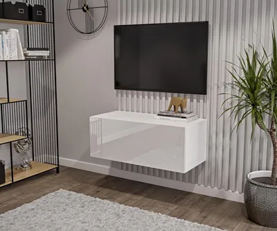 A modern living room with a wall-mounted TV and a white TV lowboard.