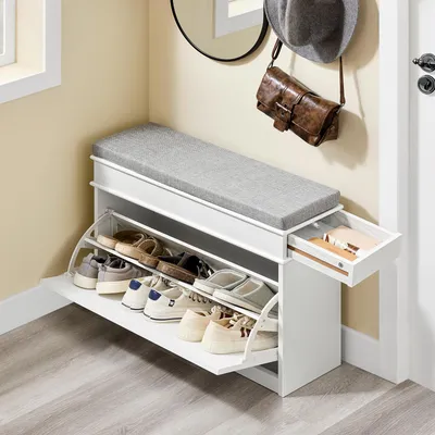 A shoe bench with storage in a hallway next to a door and a mirror.