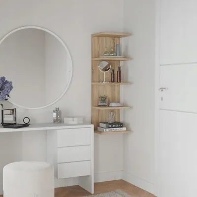 A dressing table with a round mirror and a corner shelf unit filled with toiletries.
