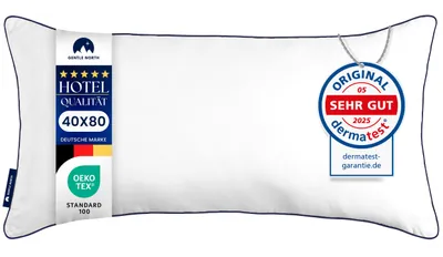 A white pillow with a dark blue trim, featuring several labels and tags.