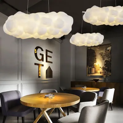 A dining area with cloud-shaped pendant lights and wooden tables.