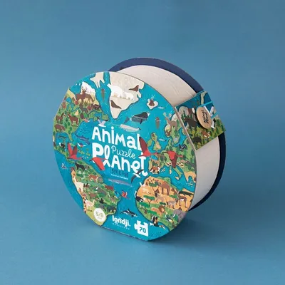A round puzzle box with an illustration of the Earth and animals on it, set against a plain blue background.