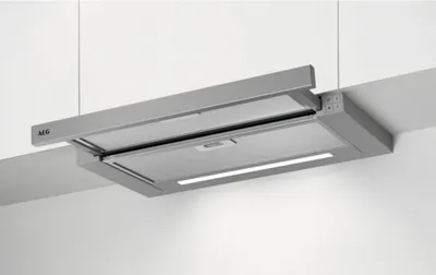 A gray AEG range hood is mounted under white kitchen cabinets.