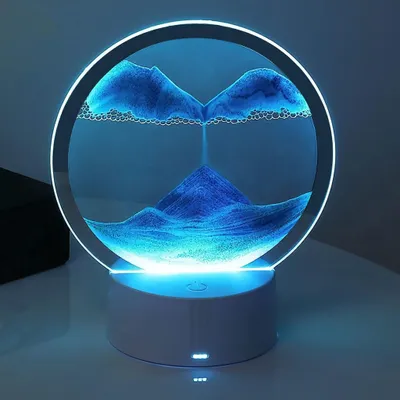 A circular sand art lamp with blue sand flowing inside, illuminated by LED lights.