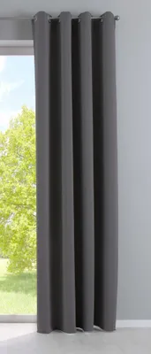 A dark gray curtain hanging in front of a window with trees visible outside.