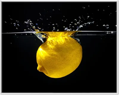Produktbild von Wallario Wandbild Zitrone im Wasser - Frisches Obst für die Küche, Größe: 40,30 x 50,30 cm, Poster mit weißem Aluminiumrahmen
