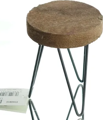 A close-up of a small plant stand with a wooden top and metal legs.