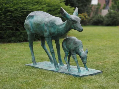 Eine Rehmutter mit Kitz in grün auf Sockel aus Bronze