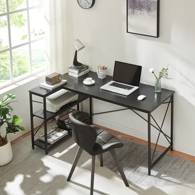 A home office setup with a black L-shaped desk, laptop, printer, and chair.