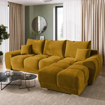 A modern living room with a large sectional sofa, coffee table, and curtains.