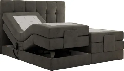 A dark gray upholstered boxspring bed with an adjustable headrest and footrest is shown against a white background.