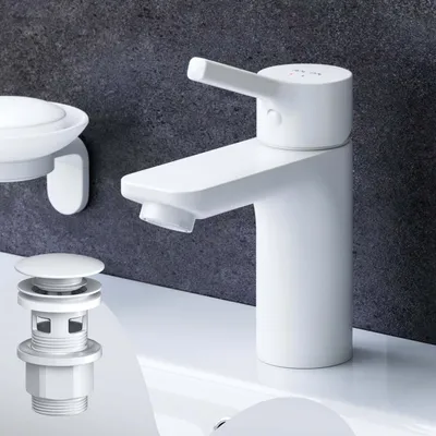 A white bathroom faucet and drain assembly are shown on a white sink against a dark gray textured wall.