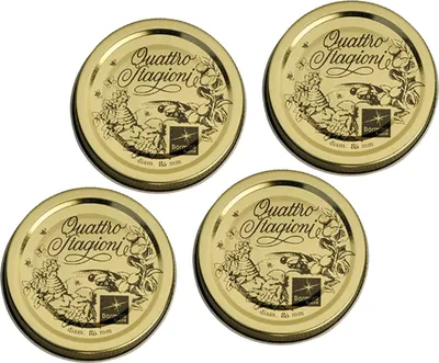 Four golden jar lids with decorative designs.