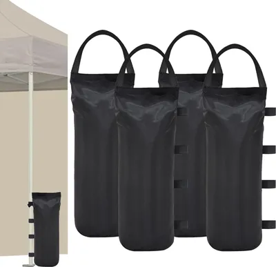 Four black sandbags for tent weights are displayed against a white background, with a portion of a tent visible on the left.
