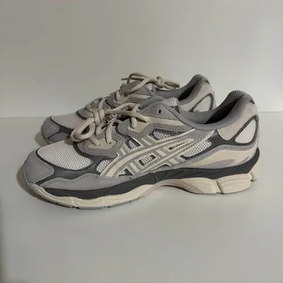 A pair of Asics Gel-NYC sneakers in Oyster Grey are displayed against a plain white background.