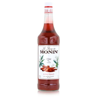 A bottle of Monin Cinnamon syrup against a white background.