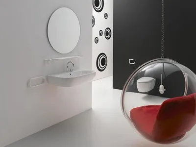 A modern bathroom with a sink, mirror, and a unique hanging bubble chair.