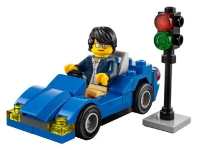 A Lego minifigure driving a blue Lego car next to a Lego traffic light.