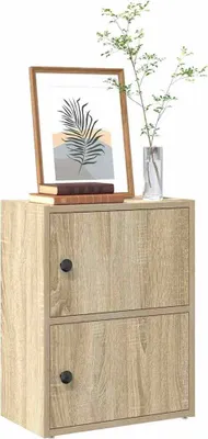 A wooden cabinet with two doors, decorated with a framed picture and a plant in a vase.