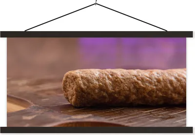 Produktbild von MuchoWow® Textilposter Eine Nahaufnahme eines frittierten Frikandels 150x75 cm mit schwarzem Rahmen - Posterleiste