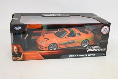 A toy car in its packaging, with a figure of Vin Diesel and the Fast & Furious logo.