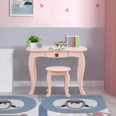 A child's pink vanity desk and stool set in a room with pink and gray walls.