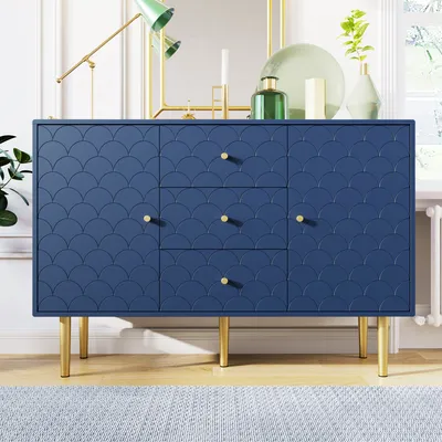 A navy blue sideboard with a scale pattern and gold legs is displayed in a room with a lamp and mirror.