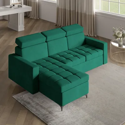 A green sectional sofa with a chaise lounge is shown in a well-lit living room setting, with a coffee table and curtains visible in the background.