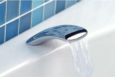 A close-up of a modern bathtub faucet with water flowing out.