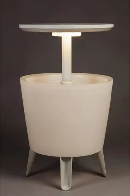 A white illuminated bar table with a round top and a cylindrical base supported by three legs, set against a plain gray background.