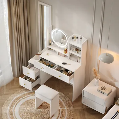 A white vanity table with a mirror and stool, set up in a room with curtains and a bedside table.