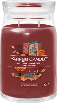 A Yankee Candle Autumn Daydream scented candle in a glass jar with a lid.