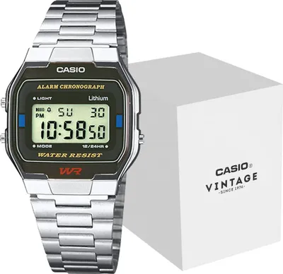A Casio digital watch with a metal band is shown next to its white product box.