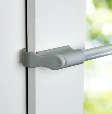 Close-up of a tension rod bracket attached to a white door frame.