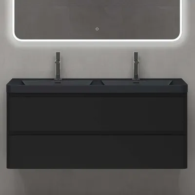 A modern black double vanity sink with faucets mounted on a gray tiled wall with a backlit mirror above.