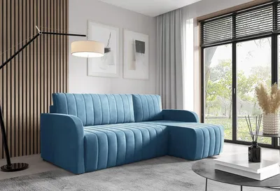 A modern living room with a blue sectional sofa, a floor lamp, and a large window.