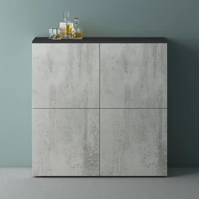 A modern sideboard with a concrete-look finish and a black top, set against a teal wall.
