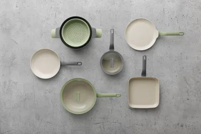 A collection of cookware arranged on a textured gray surface.
