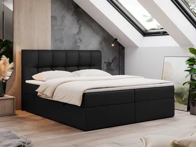 A bedroom with a black boxspring bed, skylights, and a plant.