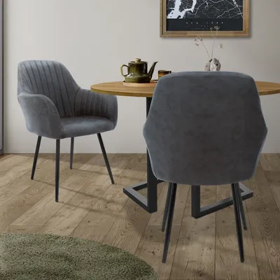 Two chairs are placed around a round wooden table in a dining area.