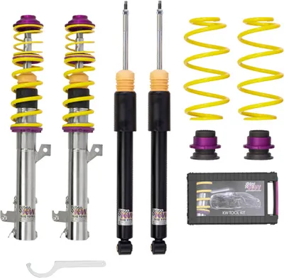 A set of car suspension components, including shock absorbers, springs, and adjustment tools, laid out on a white background.