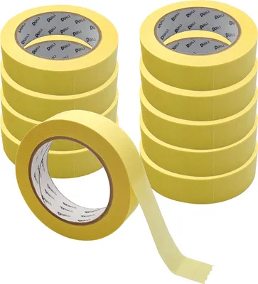 Several rolls of yellow masking tape are stacked and one roll is in the foreground with tape unrolled.